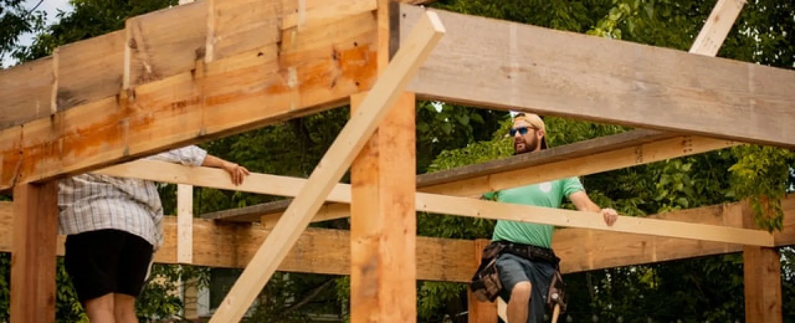 Workers building timber roof framing