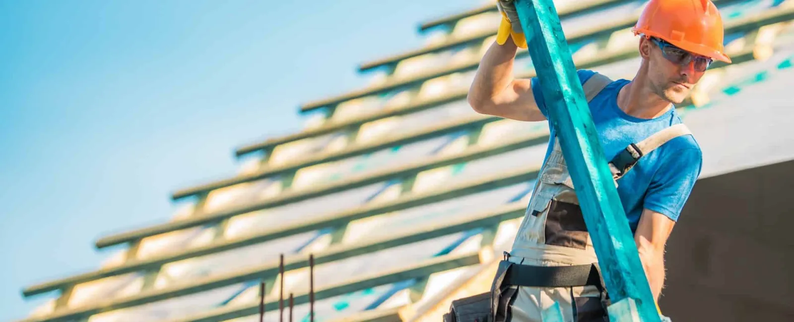 Roofer climbing a ladder on a tile roof