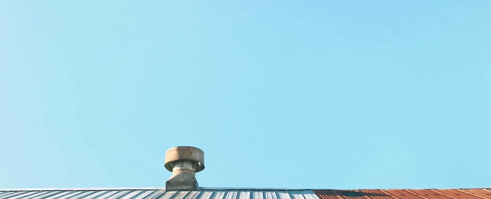 Roof vent on a flat roof against a blue sky