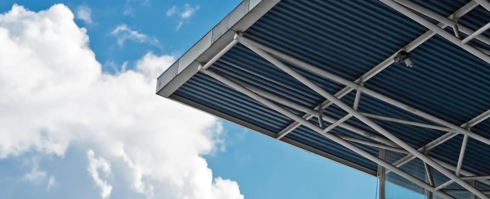 Metal canopy against a cloudy sky