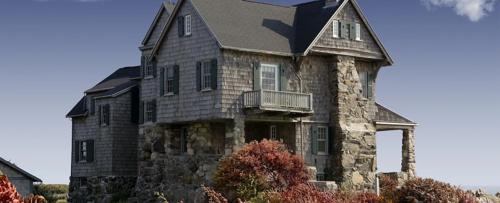 Stone house with a steep dark shingle roof
